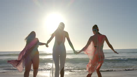 tres mujeres jóvenes disfrutan de un día soleado en la playa