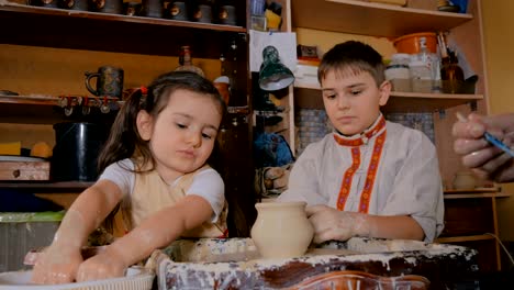 potter showing how to work with ceramic in pottery studio