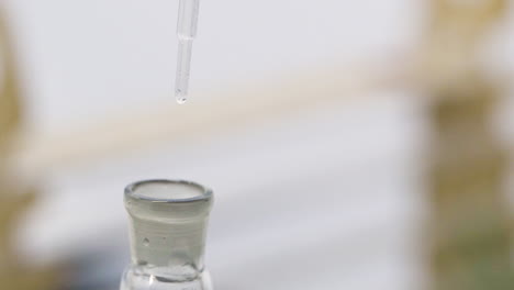 scientist carefully drips water into test tube in slow motion using an eye dropper for precise measurements