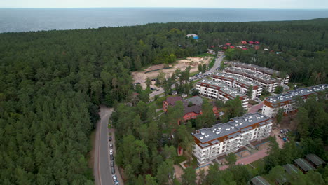 aerial backwards shot of forest landscape, sea and residential area of stegna in poland