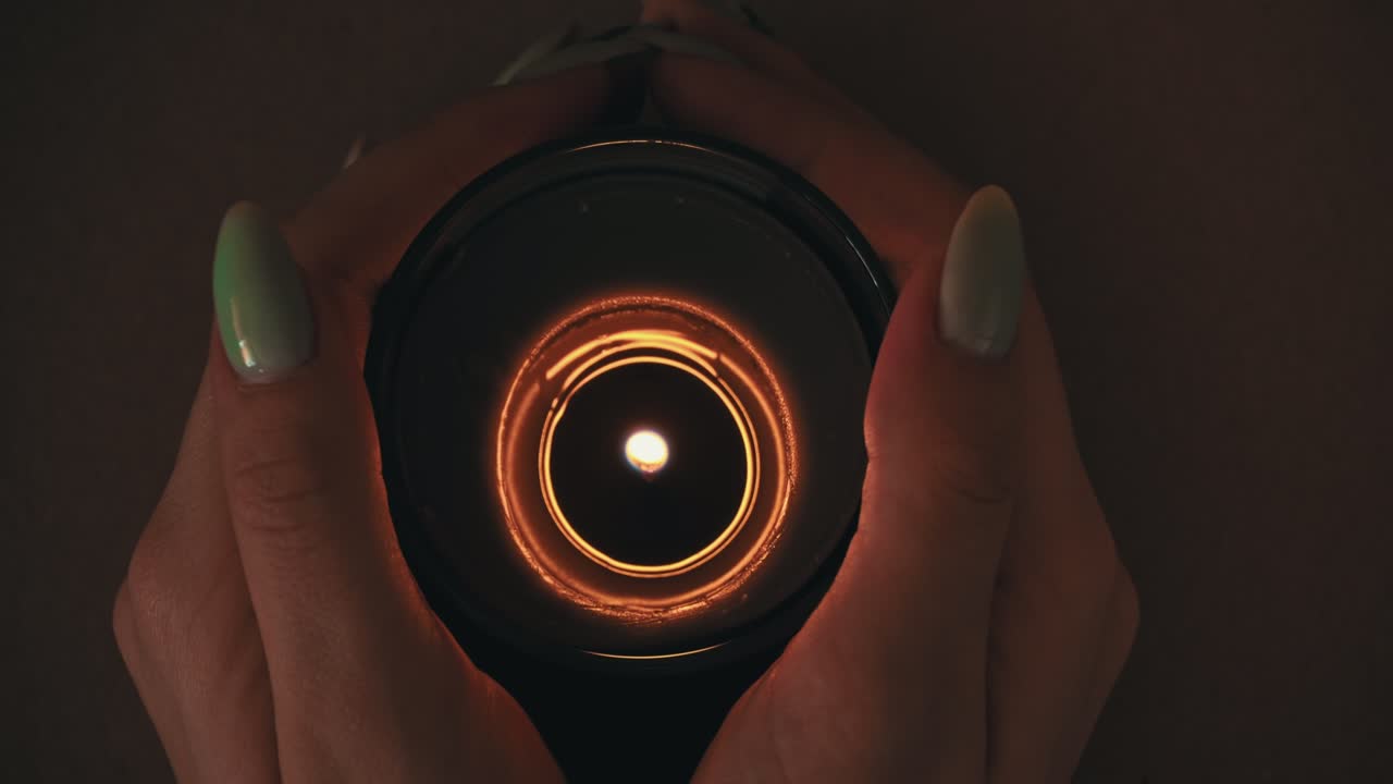 불은 아름다운 매니큐어를 가진 소녀의 손에 대기적으로 불타고 있습니다.