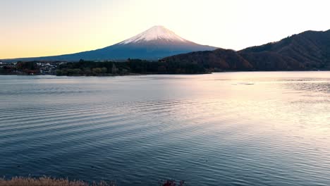 esta impresionante grabación de drone captura la vibrante puesta de sol de otoño sobre el lago kawaguchiko, mostrando el follaje rojo y el monte fuji que se levanta en el fondo.