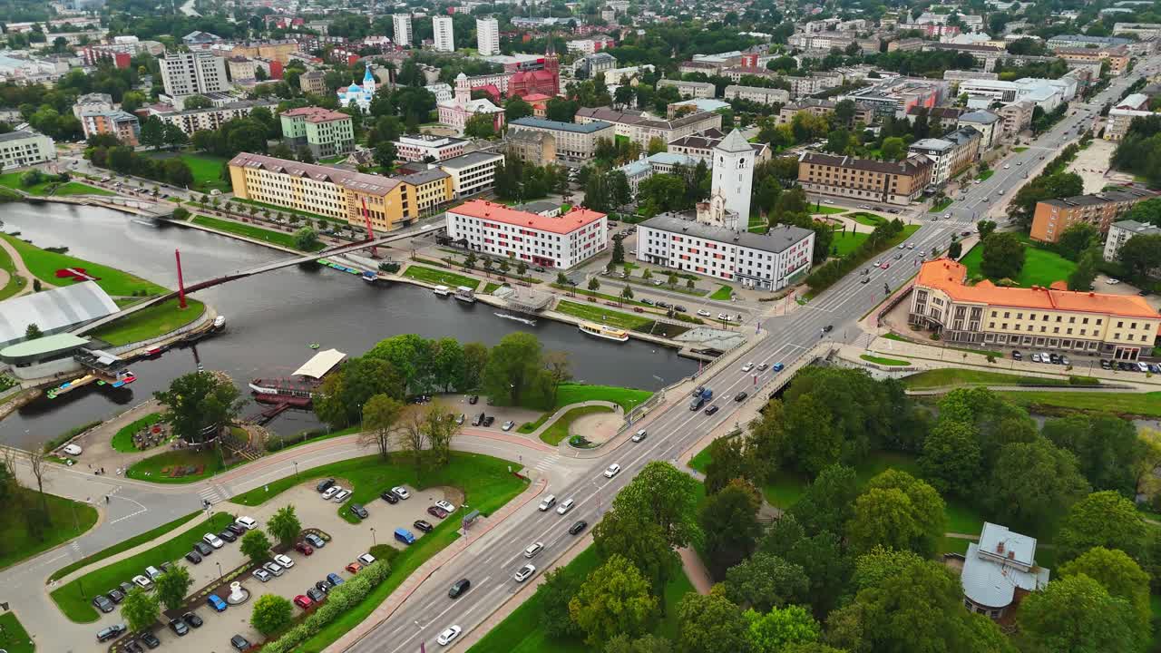 Wide orbit drone shot of Jelgava bridge, river and city in Latvia