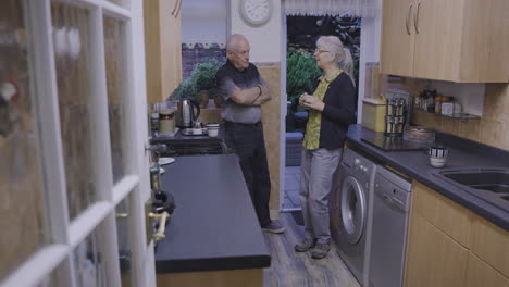 two people talking in a kitchen