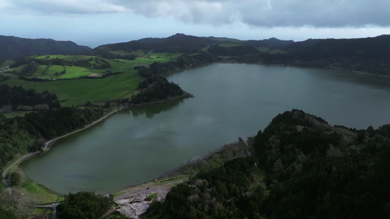 un dron aéreo revela el paisaje natural de la laguna azul en las azores. la luz del día en portugal. el horizonte por encima del paisaje verde y húmedo de las montañas.