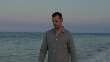 thoughtful lonely man walk along the tropical beach in silence, contemplating his pas, present and future life during the sunset.