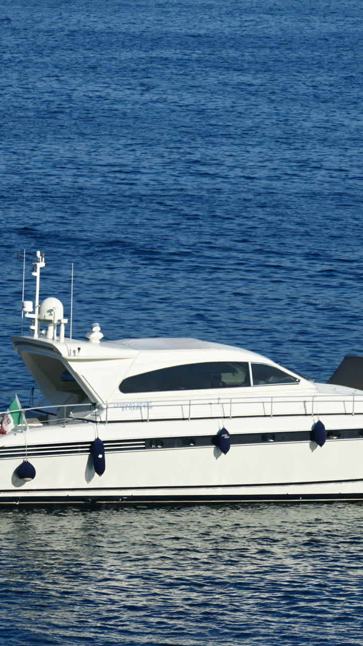White boat docked in the local harbour in Villefranche sur Mer, France. Vertical
