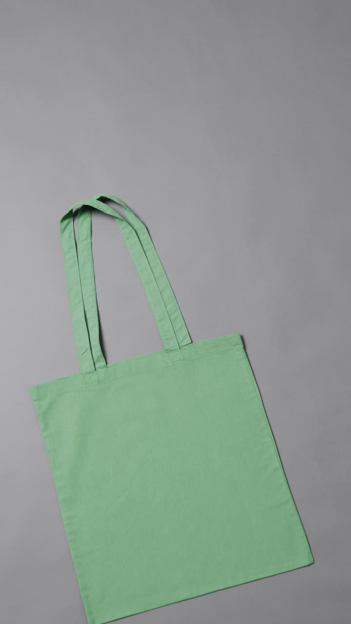Vertical video of high angle view of green canvas bag with copy space on white background