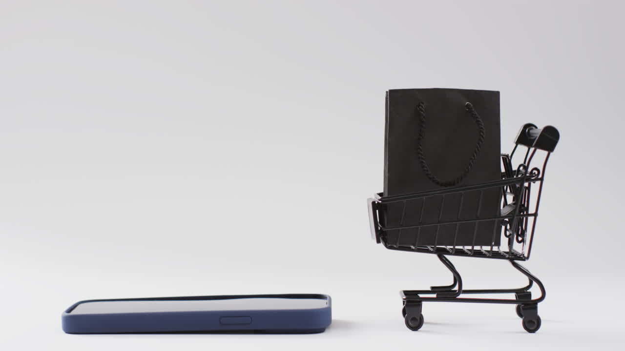 vídeo de un teléfono inteligente, una bolsa de compras y un carrito con espacio de copia sobre un fondo blanco