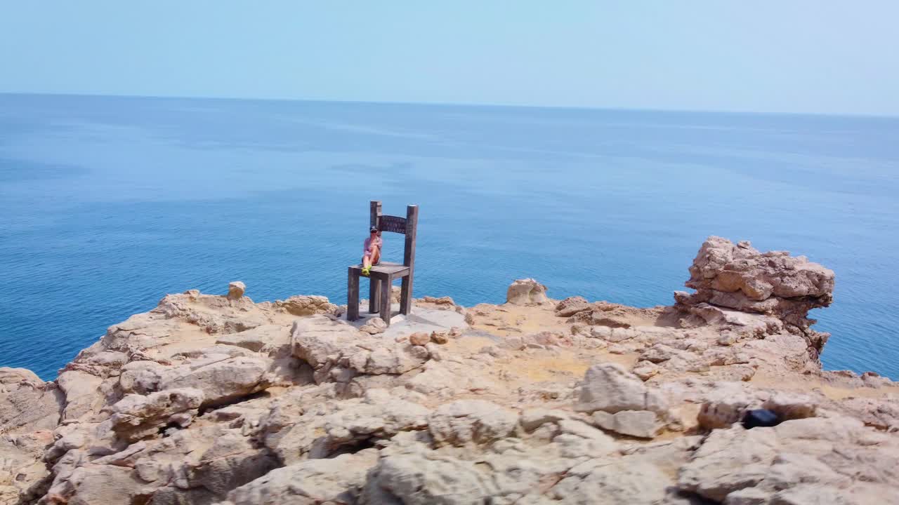 mujer sentada sobre un monumento al punto sur de europa.
