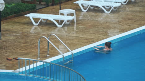 sensuele jonge vrouw ontspant zich in het zwembad.