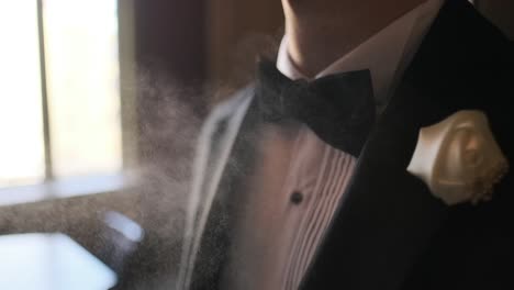 A-guy-is-choosing-perfumes,-Elegant-man-in-suit-using-cologne,groom-getting-ready-in-the-morning-before-wedding-ceremony