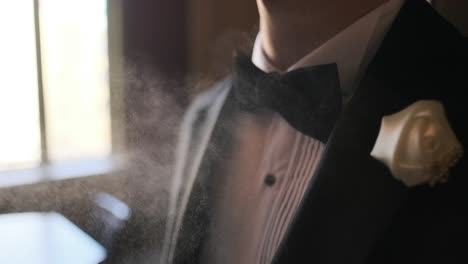 Un-Tipo-Está-Eligiendo-Perfumes,-Un-Hombre-Elegante-Con-Traje-Usando-Colonia,-El-Novio-Preparándose-En-La-Mañana-Antes-De-La-Ceremonia-De-La-Boda