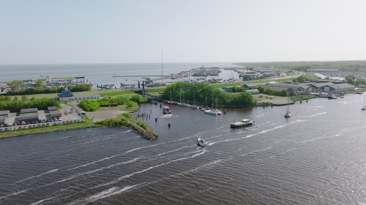 the harbour at Lauwersoog in the Netherlands, as observed from above. The video showcases the coastal infrastructure, as well as the surrounding green landscape that leads into the North Sea
