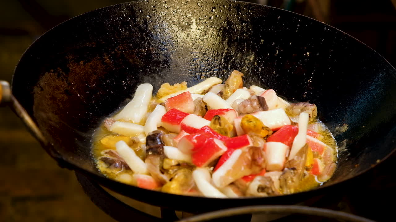 Pack of seafood mix added to hot melted butter in large wok; static