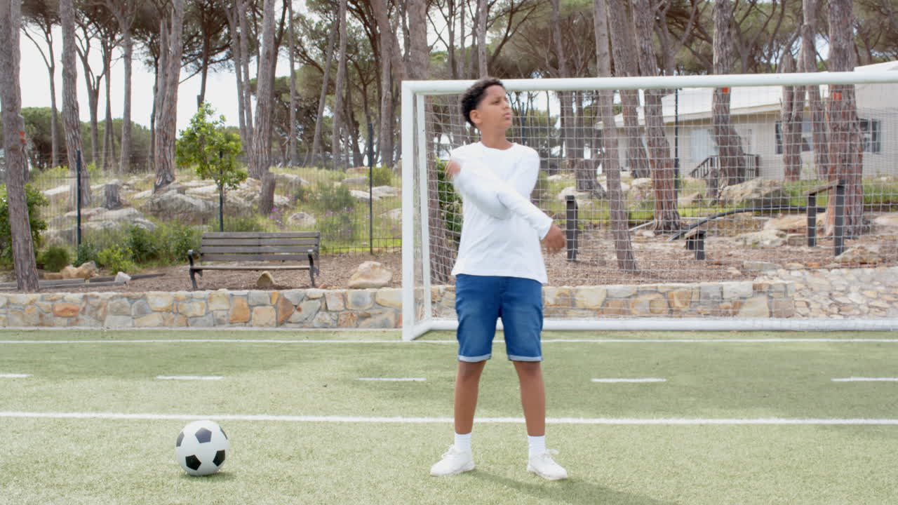 Boy celebrating on soccer field near goalpost, enjoying outdoor sports activity, copy space