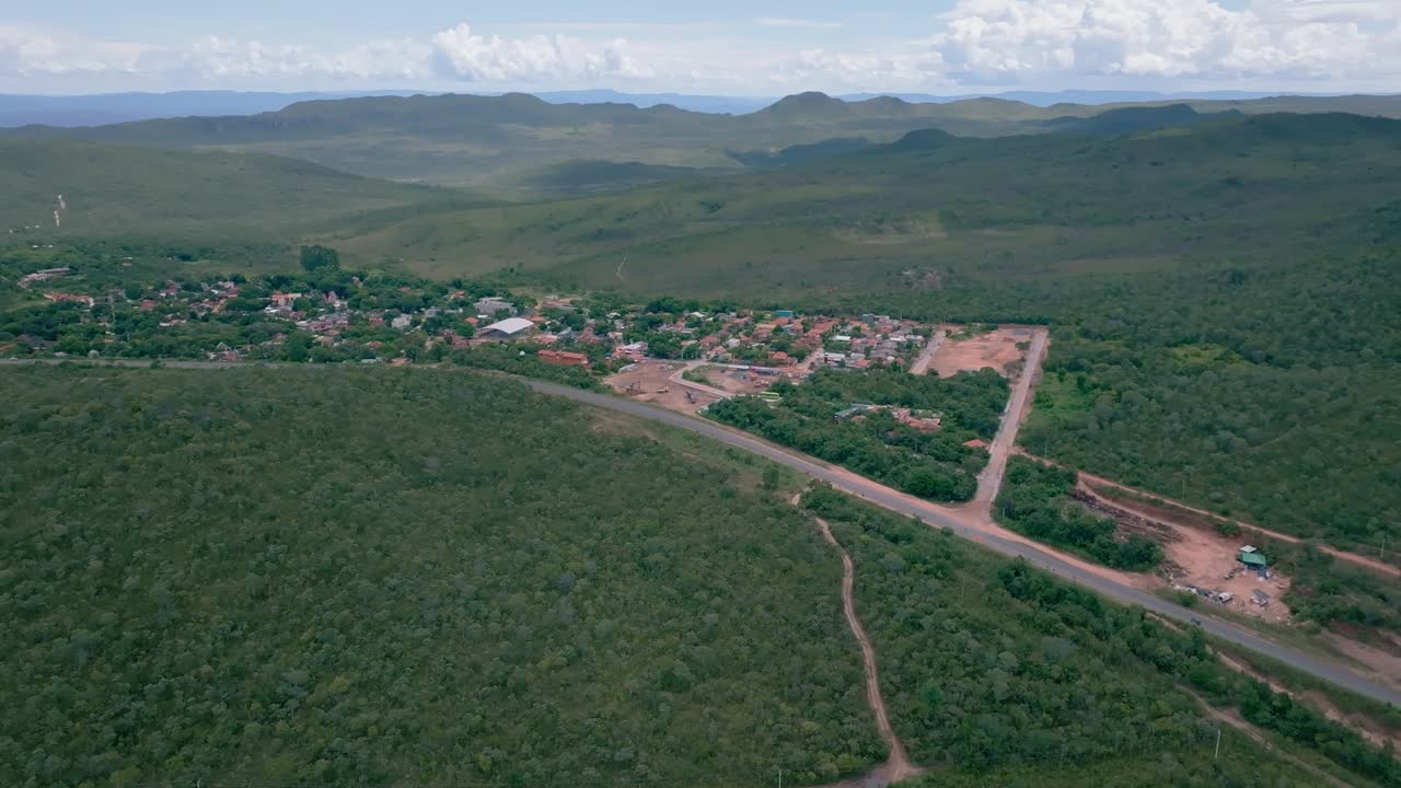 Aerial view capturing Vila de Sao Jorge in Alto Paraiso de Goias, showcasing its houses, roads, and lush vegetation within Chapada dos Veadeiros National Park in Brazil