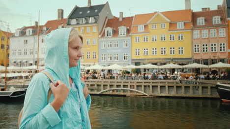 a woman strolls along the canal against the background of famous colorful houses the most popular pl