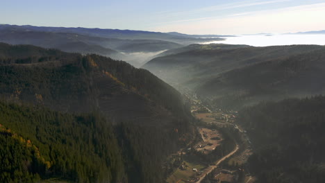 Flyover-above-Balan-town-in-valley-of-foggy-Hasmas-Mountain-Romania