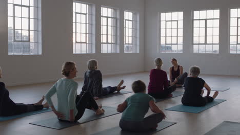 yoga class instructor teaching group of mature women meditation practice showing pose enjoying morning physical fitness workout in studio