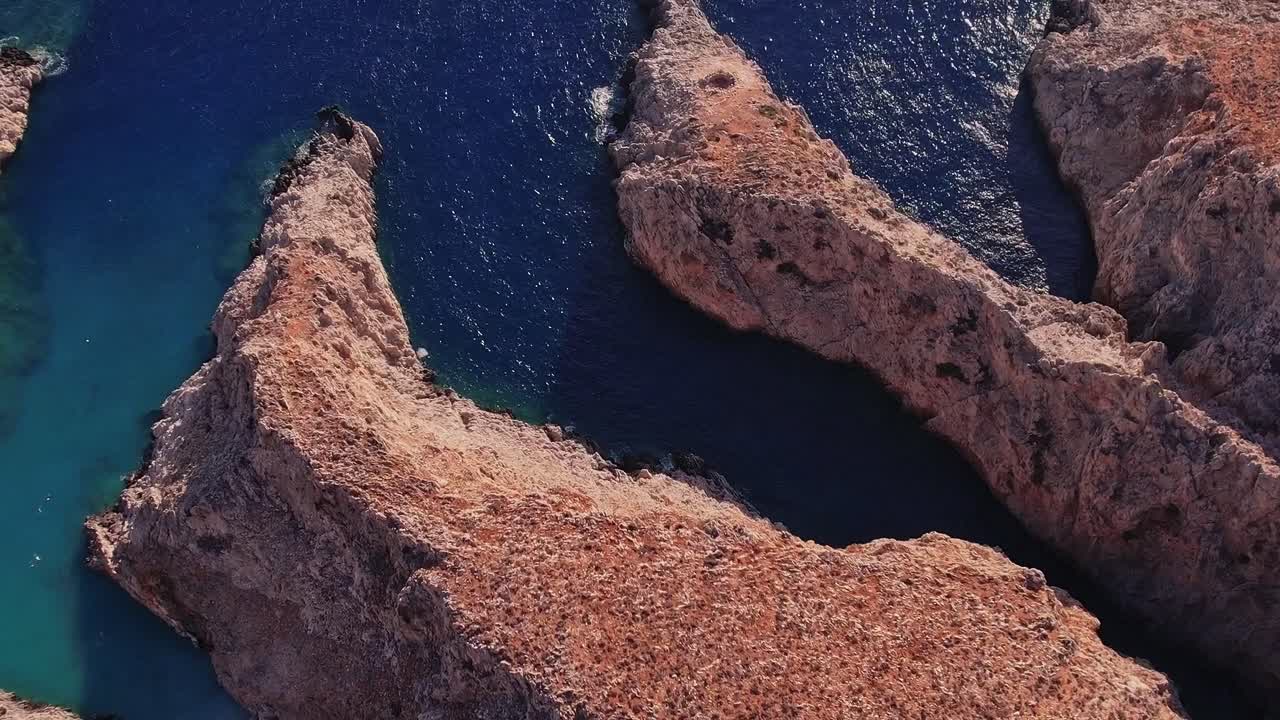 Vista aerea di costa rocciosa con calette turchesi e mare blu