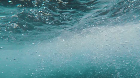 camera diving underwater into and out of a fast moving and rocky river, great transition shot