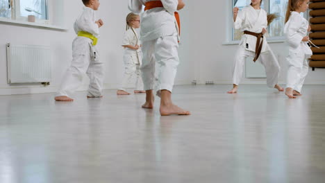 unrecognizable kids in white kimono in martial arts class