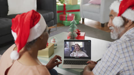 Glückliches-Afroamerikanisches-Seniorenpaar-Beim-Laptop-Videoanruf-Mit-Freundin-Zur-Weihnachtszeit