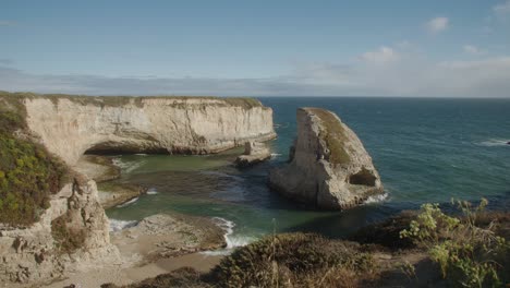 Toma-De-Establecimiento-De-La-Cala-De-Aleta-De-Tiburón,-Vista-Desde-Un-Acantilado-Con-Olas-Rompiendo-Suavemente.