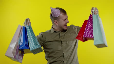 hombre levantando bolsas de compras, pareciendo satisfecho con la compra, disfrutando de descuentos en el viernes negro