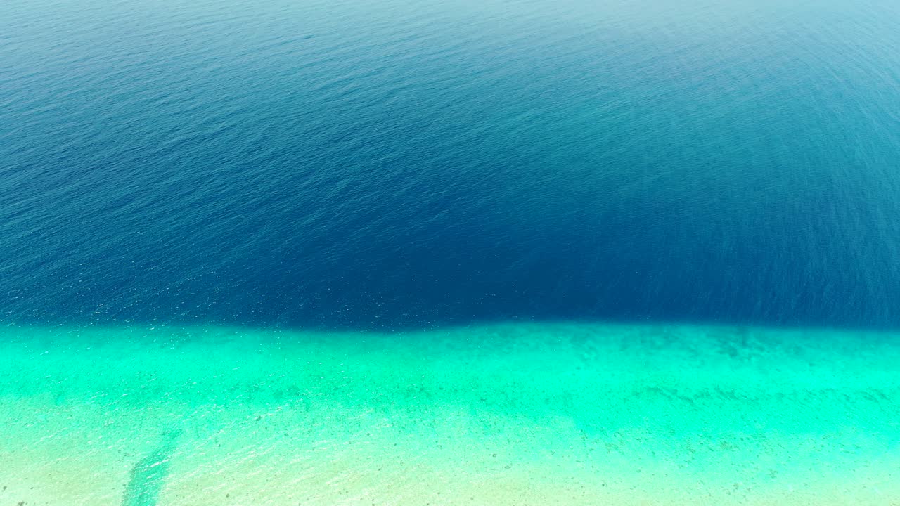 Aerial tropical abstract background. Tupai Heart Island Coral Reef Atoll In French Polynesia, Beautiful deep blue ocean meets turquoise shallow water