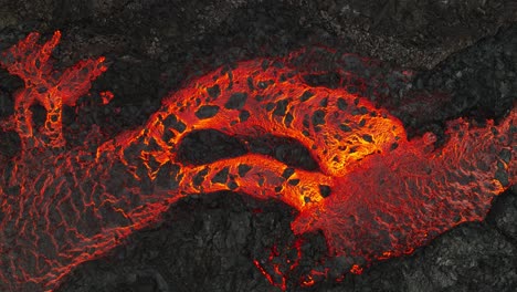 aerial view over the lava stream textures, coming from the volcanic eruptions at litli-hrutur, iceland, with smoke coming up