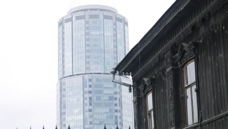 modern skyscraper and old wooden house