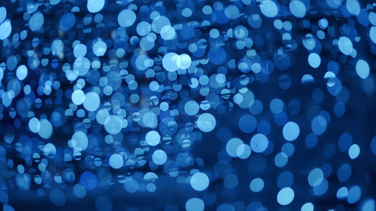 추상적인 배경은 크리스마스 보케 공을 가지고 있습니다. 새해 휴일 배경은 전구 장미의 반이는 불빛과 함께. 밤에는 밝은 겨울 파티 불빛의 실제 렌즈 흐릿함.