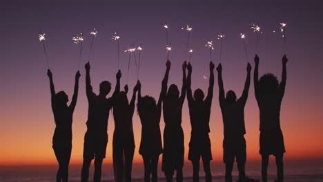 Schatten-Von-Freunden,-Die-Am-Strand-Mit-Feuer-Spielen