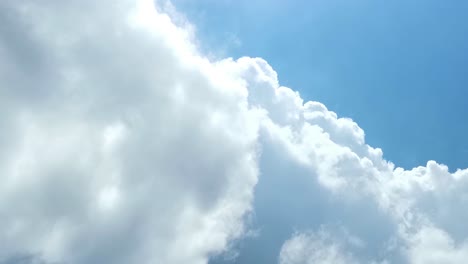 Half-of-blue-sky-and-white-clouds-under-bright-sun,-bad-weather-coming