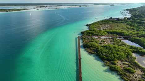 Vista-Aérea-Del-área-Natural-Protegida-Parque-Laguna-De-Bacalar,-En-El-Soleado-México---Reversa,-Inclinación,-Disparo-De-Drones