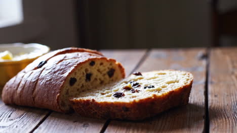 a hand taking a slice of homemade raisin bread