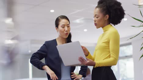 Group-of-diverse-business-people-using-laptop-and-talking-in-office,-slow-motion