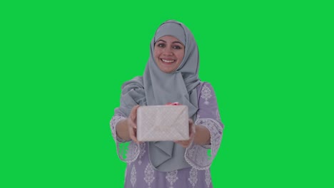 happy muslim woman giving a gift green screen