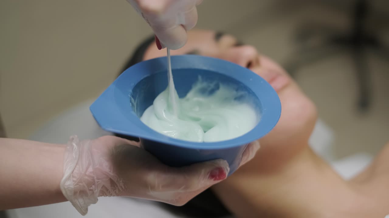 mujer hermosa con máscara facial en un salón de belleza