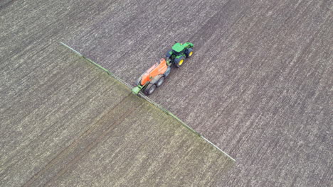 un tractor rociando fertilizante en un campo