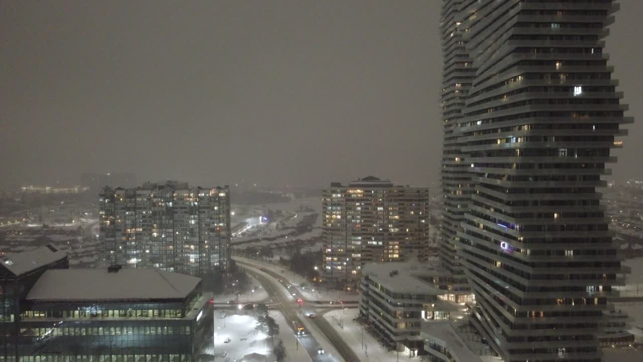 Aerial establishing shot of downtown Mississauga after a blizzard at night