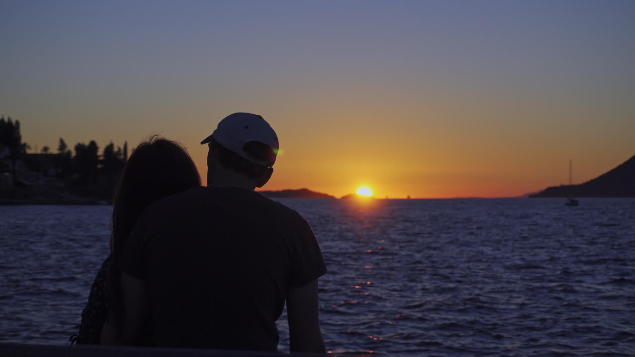 Silhouette Of Romantic Couple Watching The Sunset In Ocean - wide