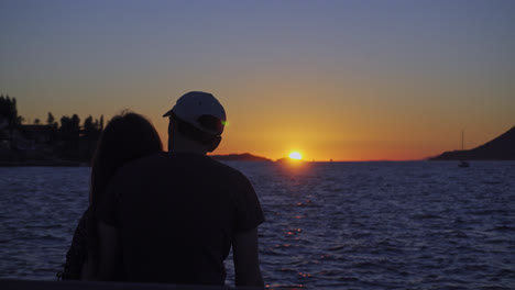 silhouette of romantic couple watching the sunset in ocean - wide