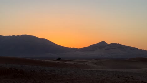 Berglandschaft-Bei-Sonnenuntergang-Mit-Trockener-Wüstenlandschaft-Und-Orangefarbenem-Himmel