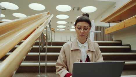 Frau-Benutzt-Laptop-Auf-Bibliothekstreppe