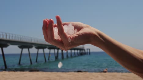 ice melting in hand on a beach
