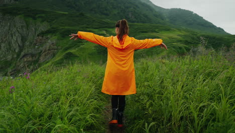 woman hiking in mountains with rain gear