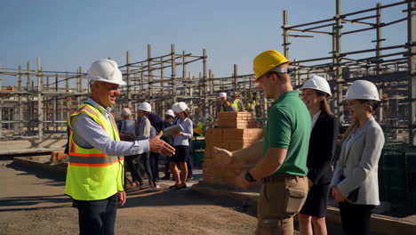 construction workers or engineers shaking hands on a building site